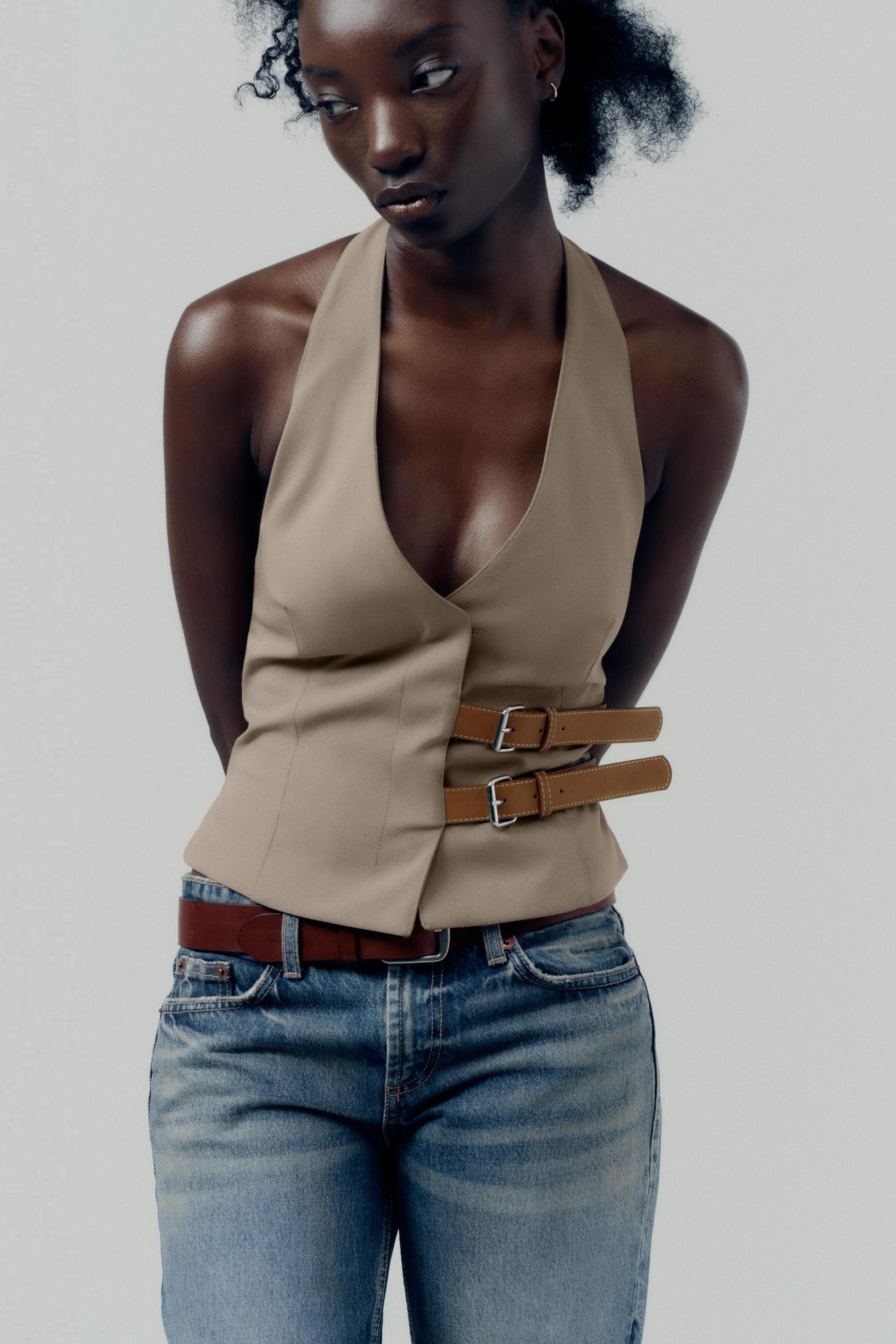 topwear,tops,semi formal, outdoor events,creative workwear, minimal, sophisticated,stretchable,polyester, spandex,beige,solid,contrast,buckle, button, belt,tailored fit,fitted,waist length,v-neck,sleeveless	OY1711,25010066GG