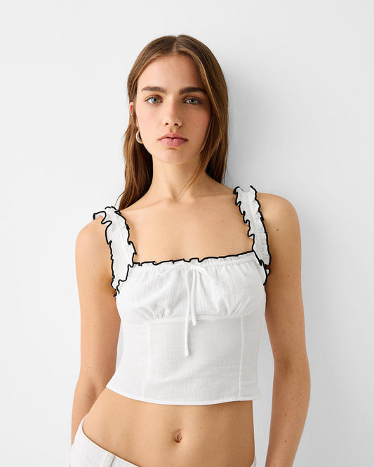 ruffled-edge-crop-top-white,topwear,tops,casual,soft girl,woven,cotton crepe,white,solid,ruffled,slim fit,crop,crop,square neck,shoulder strap,sleeveless,Color: White
Fabric: Cotton Crepe
Fit: Slim Fit 
Length: Crop
Neck: Square Neck
Print: Solid
Details: Ruffled edges in black creates a striking contrast, the square neckline features subtle gather and drawstring for added detail,RUFFLED EDGE CROP TOP