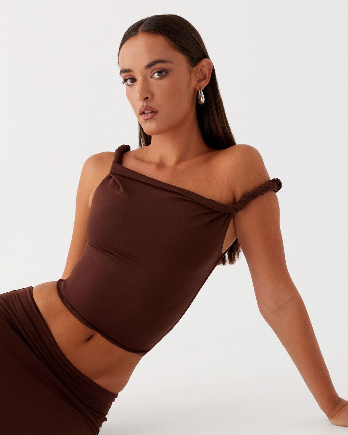 twisted-shoulder-strap-fitted-top-brown-oy1501,25010001GG52,topwear,tops,party, vacation,bold, glam, streetwear,knitted, stretchable,ribbed,brown,solid,twisted,skinny fit,fitted,regular,one shoulder,shoulder strap,sleeveless,Color: Brown coord sets,skirts,vacation,beach, glam, summer, streetwear,knitted,ribbed,brown,twisted,skinny fit,pencil skirt,full len
Fabric: Ribbed
Fit: Skinny Fit 
Length: Regular
Neck: One Shoulder
Print: Solid 
Details: Twisted shoulder strap ,TWISTED SHOULDER STRAP FITTED TOP