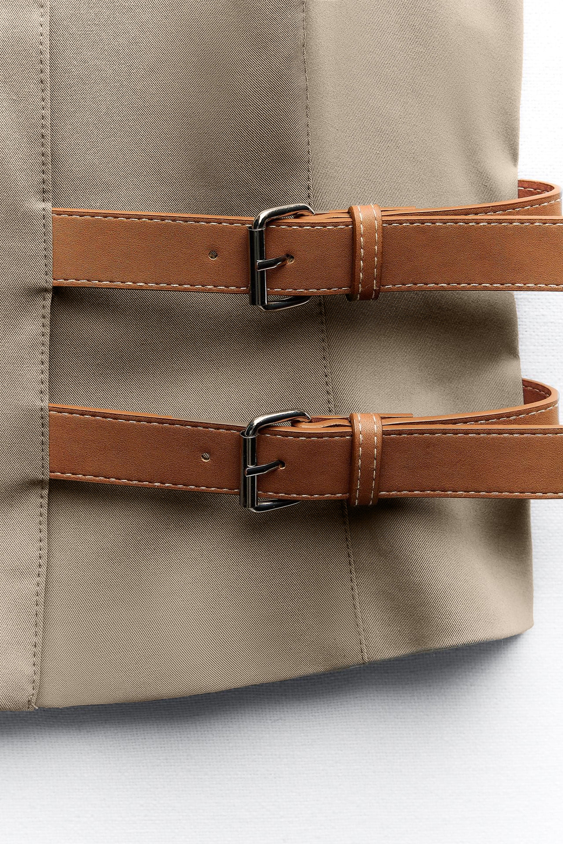 topwear,tops,semi formal, outdoor events,creative workwear, minimal, sophisticated,stretchable,polyester, spandex,beige,solid,contrast,buckle, button, belt,tailored fit,fitted,waist length,v-neck,sleeveless	OY1711,25010066GG