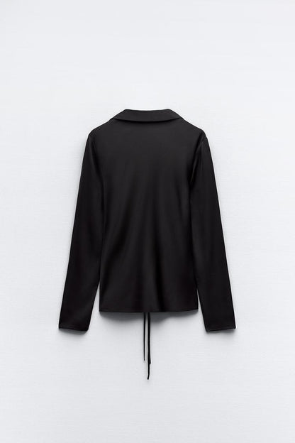 TIE UP LONGLINE TOP,black, collared neck, glam, long sleeves, longline, regular fit, satin, solid, streetwear, summer, tops, topwear, vacation, woven,straight-fit-front-drawstring-closure-black-shirt,Neck - Collared with plunging neckline 
 Sleeve - Long sleeves
 Fit - Straight fit
 Print/Pattern - Solid
 Color - Black
 Material - Satin
 Detail - Front opening with drawstring closure